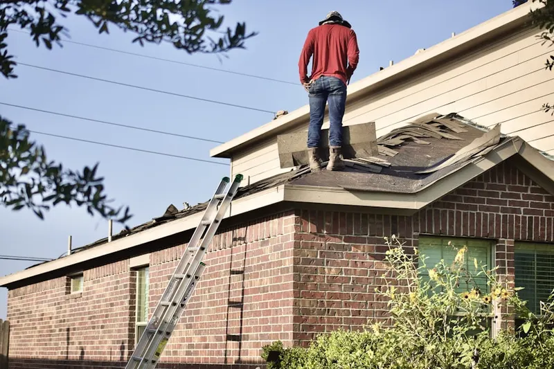 Professional roofer working on a residential roof in Fieldstone